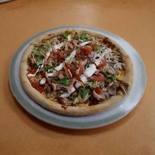 Pizza kebab con mozzarella, carne, insalata mista e salse