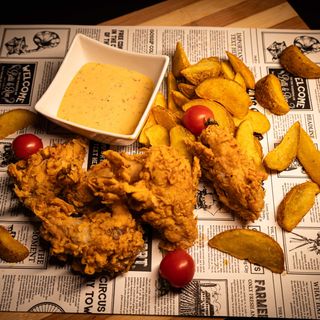 Aripioare crocante picante cu sos chilli-usturoi servite cu cartofi wedges