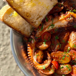 Tentáculos de pulpo al estilo siciliano con tomates y papas nuevas 