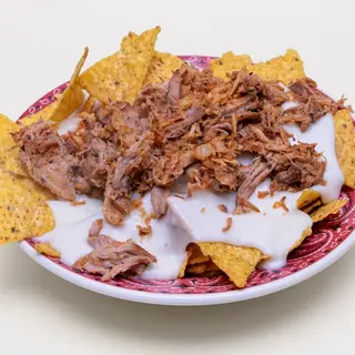 Nachos con fonduta di formaggio, sfilacciata di maiale CBT e cipolla fritta