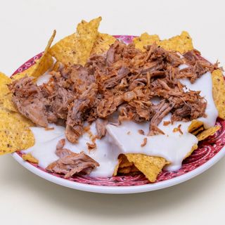 Nachos con fonduta di formaggio, sfilacciata di maiale CBT e cipolla fritta