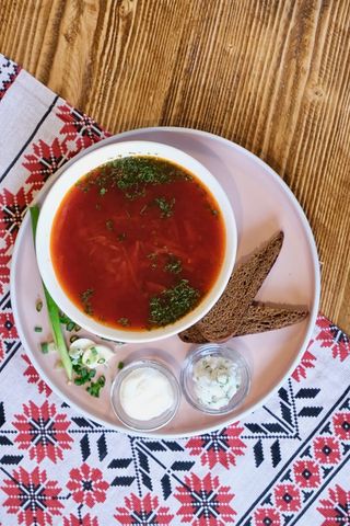 Borscht with beef served with lard, sour cream and bread
