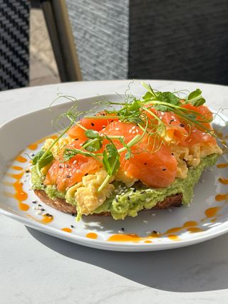 Duży awokado tost z jajecznicą i łososiem