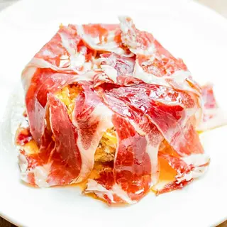 Huevos rotos con jamón ibérico y escama de patata
