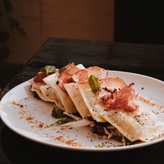 RAVIOLI FRITTI RIPIENI DI SQUAQUERONE CON POLVERE DI OLIVE NERE E CAPOCOLLO