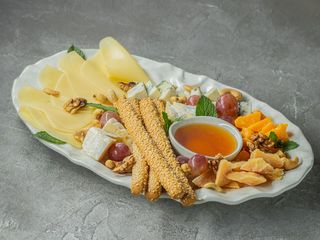 Антипасто з вишуканих сирів з медом, горіхами та хрусткими грісіні