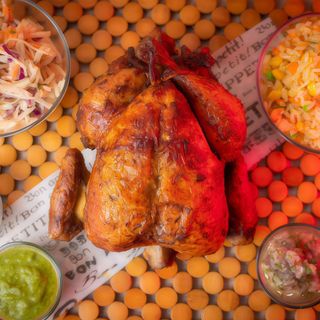 1/4 de pollo con patatas fritas y una salsa