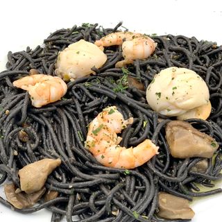Fideos negros con langostinos, vieiras y setas