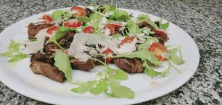 TAGLIATA DI ANGUS RUCOLA POMODORINI GRANA