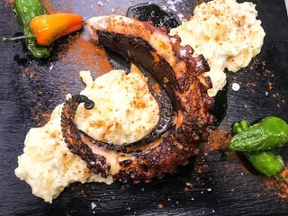 Pulpo a la brasa, sobre parmentier de patata y AOVE de pimentón