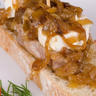 Presa De Cerdo Con Rulo De Cabra Y Cebolla Caramelizada