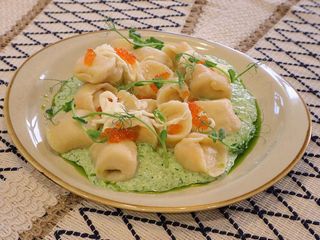 Пельмени с семгой на подушке из шпината с сыром  страчаттела и красной икрой