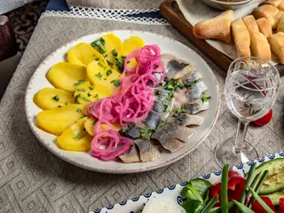Hering ușor sărat, servit cu cartofi fierți și ceapă marinată