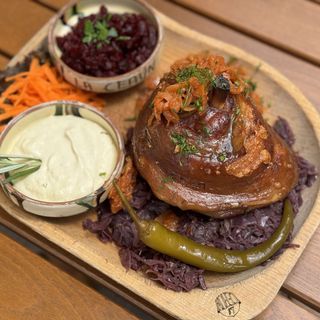 Ciolan de porc afumat pe pat de varză roșie călită si sos de hrean.