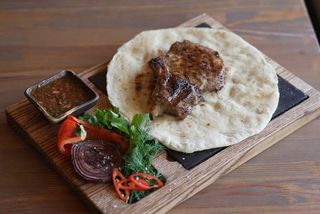 Корейка свинини на кістці з пітою та овочами на мангалі (200/80/60/50g)