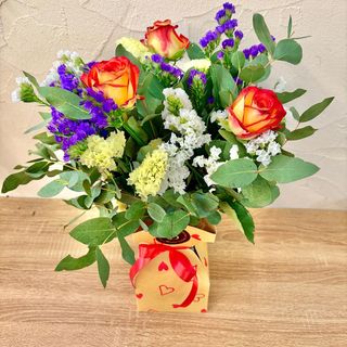 Ramo de flores de temporada en agua con jarrón de cartón plastificado