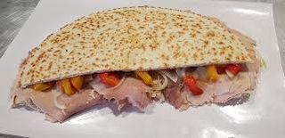 Piadina con porchetta, scamorza, cipolla, peperoni e crema di funghi