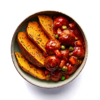 Albóndigas Heura en salsa de tomate con boniato al chimichurri