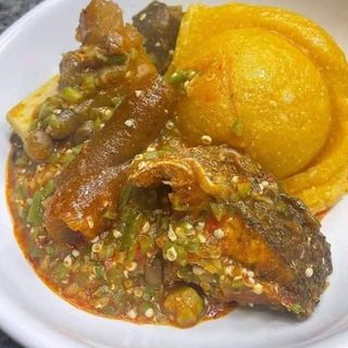 Yellow Eba served with okro soup mixed with tilapi fish and pomo