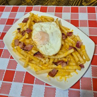 Patatas fritas con beicon, queso y huevo frito