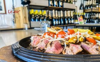 Tagliata di vitello su pietra lavica con funghi, pomodorini saltati e scaglie di grana