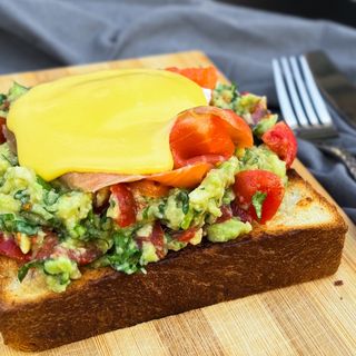 Poached egg on big toast with salted salmon, guacamole, galandaise