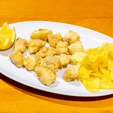 Delicias De Merluza En harina de arroz y chips de patata.