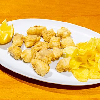 Delicias De Merluza En harina de arroz y chips de patata.