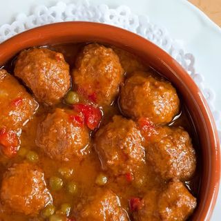 Plato de albóndigas en salsa con patatas gajo al horno