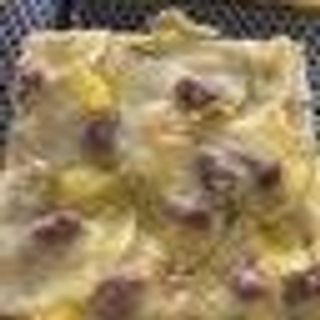 Pizza con patate, salsiccia e mozzarella al trancio 