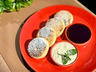 Сирники солодкі з ягідним соусом та сметаною