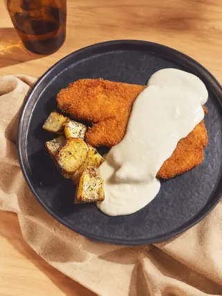 Milanesa de pollo con salsa Saona y patatas asadas