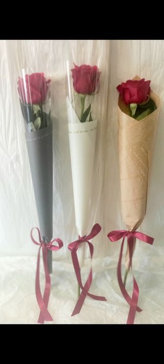 Jedna ruža u ukrasnom papiru s mašnom