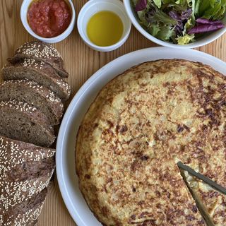 Tortilla de patatas y cebolla con acompañamiento de ensalada