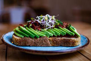 Tostada de aguacate, brotes y tomates secos