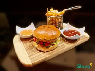 Burger Angus servit cu cartofi prajiti, sos barbeque si sos cu hribi 