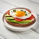 Tostada con queso untar, aguacate, tomate y huevo