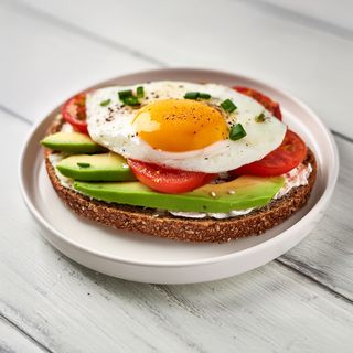 Tostada con queso untar, aguacate, tomate y huevo