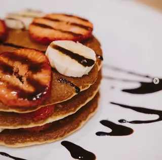 Tortitas De Plátano Y Fresa Con Sirope De Chocolate Y Nata