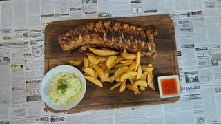 Coasta de porc (baituita cu mirodeniile casei, cartofi wedges, salata de varza alba si sos dulce) 500g