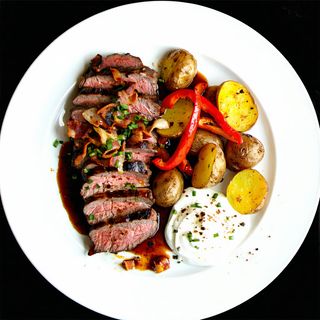 Ceafă țigănească servită cu cartofi copți și sos de smântână