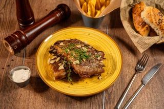 Coaste de porc în sos de vin alb şi usturoi cu garnitură