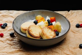 Cottage cheese syrniki with fresh fruits and sour cream with chia seeds