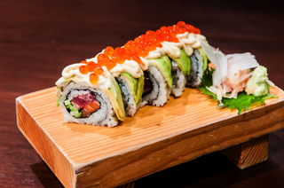 Uramaki seriola w tempurze owinięta łososiem i mango