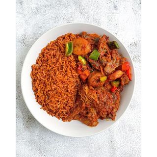A Plate of Smoked Jollof Rice with Protein and 1 Hotdog