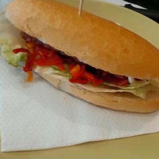Panino con salsiccia, insalata, pomodoro, ketchup e maionese
