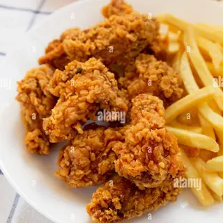 Piatto di alette fritte con verdure e patate