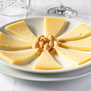 Queso postre servido con frutos secos y confitura casera