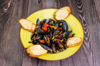 Midii in sos de vin alb si usturoi servite cu paine prajita