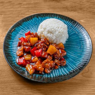 Maiale in salsa agrodolce servito con riso bianco